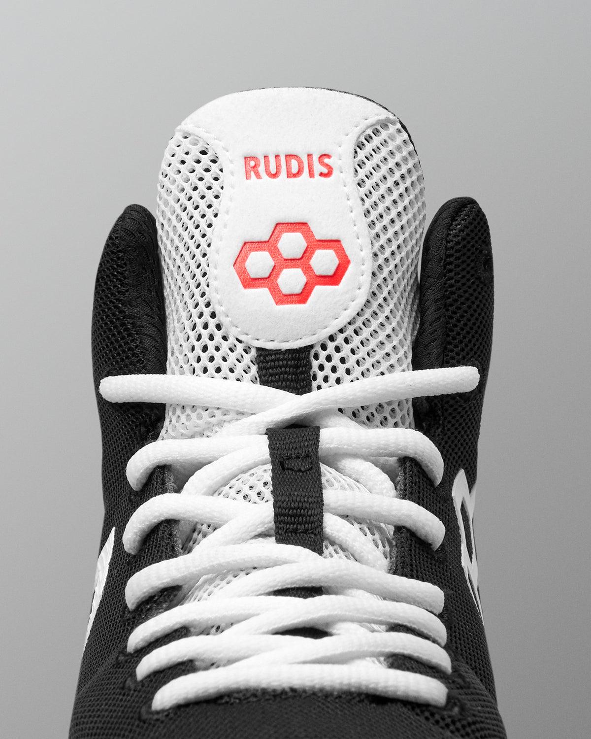 Close-up of the RUDIS Courage 2.0 Youth Wrestling Shoe tongue featuring breathable white mesh, embroidered RUDIS branding, and white performance laces.
