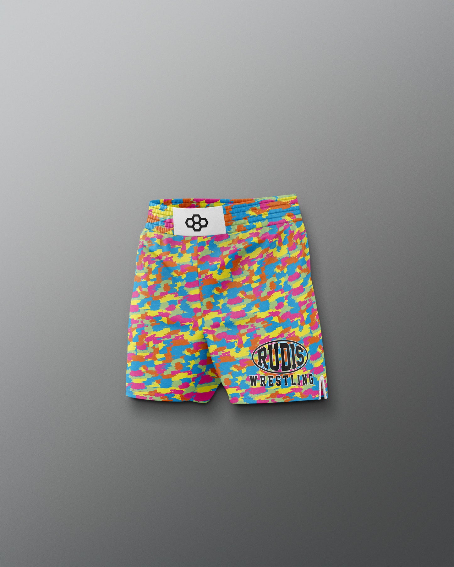 Colorful wrestling shorts with a logo on a gray background