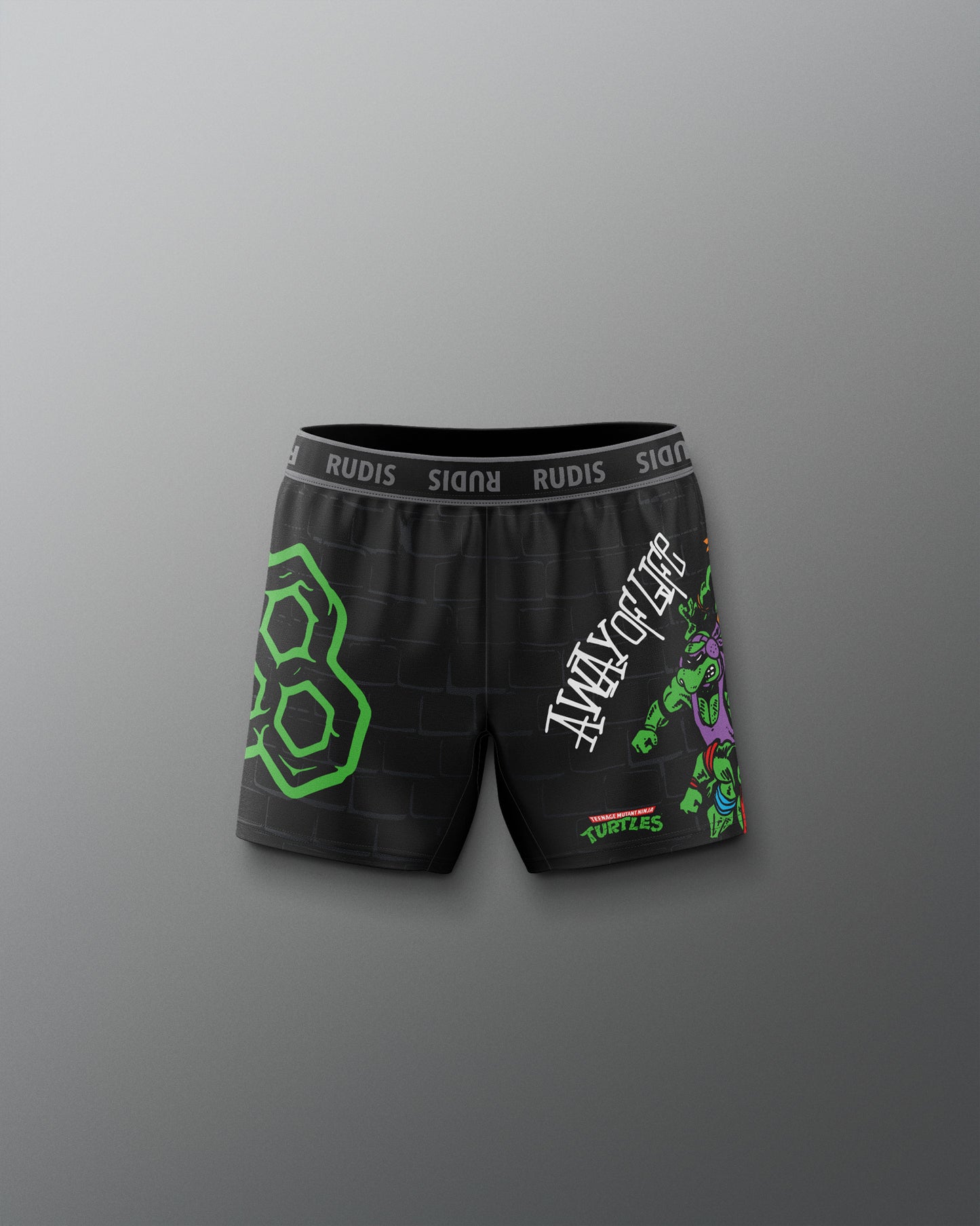 Black shorts with green and white graphics on a gray background. TMNT. Teenage Mutant Ninja Turtle