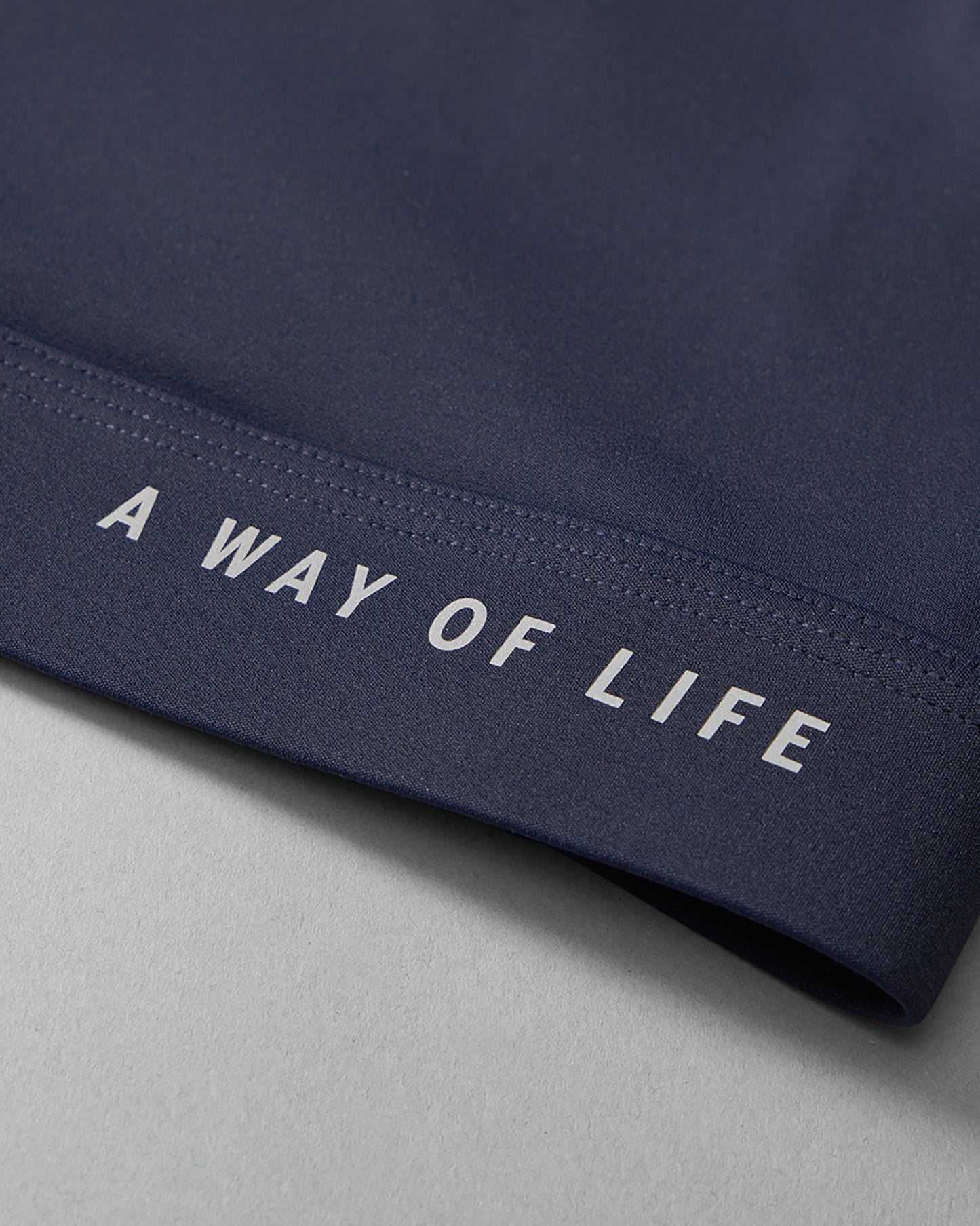 Navy blue fabric with 'A Way of Life' text on a gray background