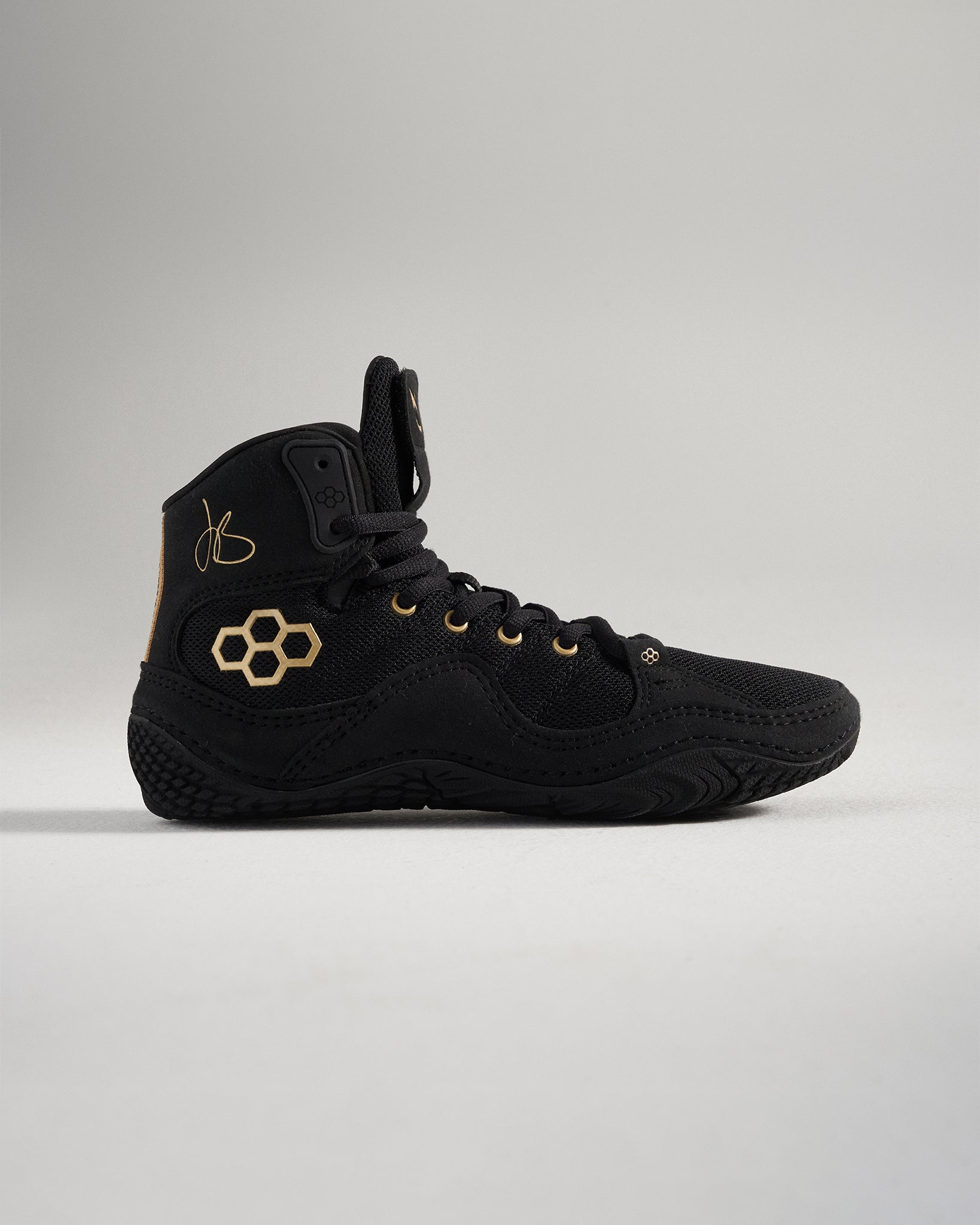 A stylish black athletic shoe featuring gold accents and a unique hexagonal logo design ideal for performance and casual wear