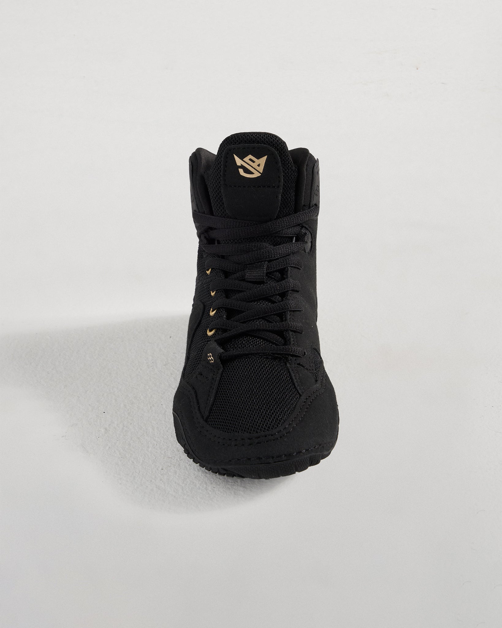 A stylish black high-top sneaker featuring a breathable mesh upper gold accents and a textured sole designed for performance and comfort