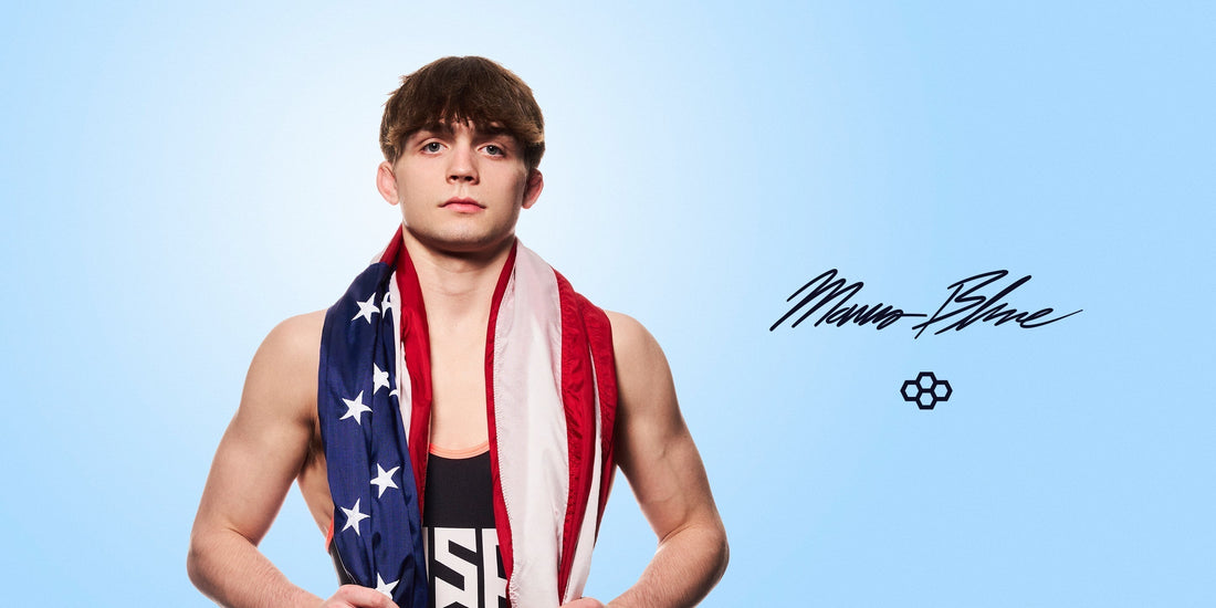 Marcus Blaze Joins Team RUDIS - Blaze standing with american flag around sholders, wearing USA wrestling singlet
