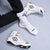 White wrestling shoes with black RUDIS Logo accents and a logo worn with white socks on a light gray floor.