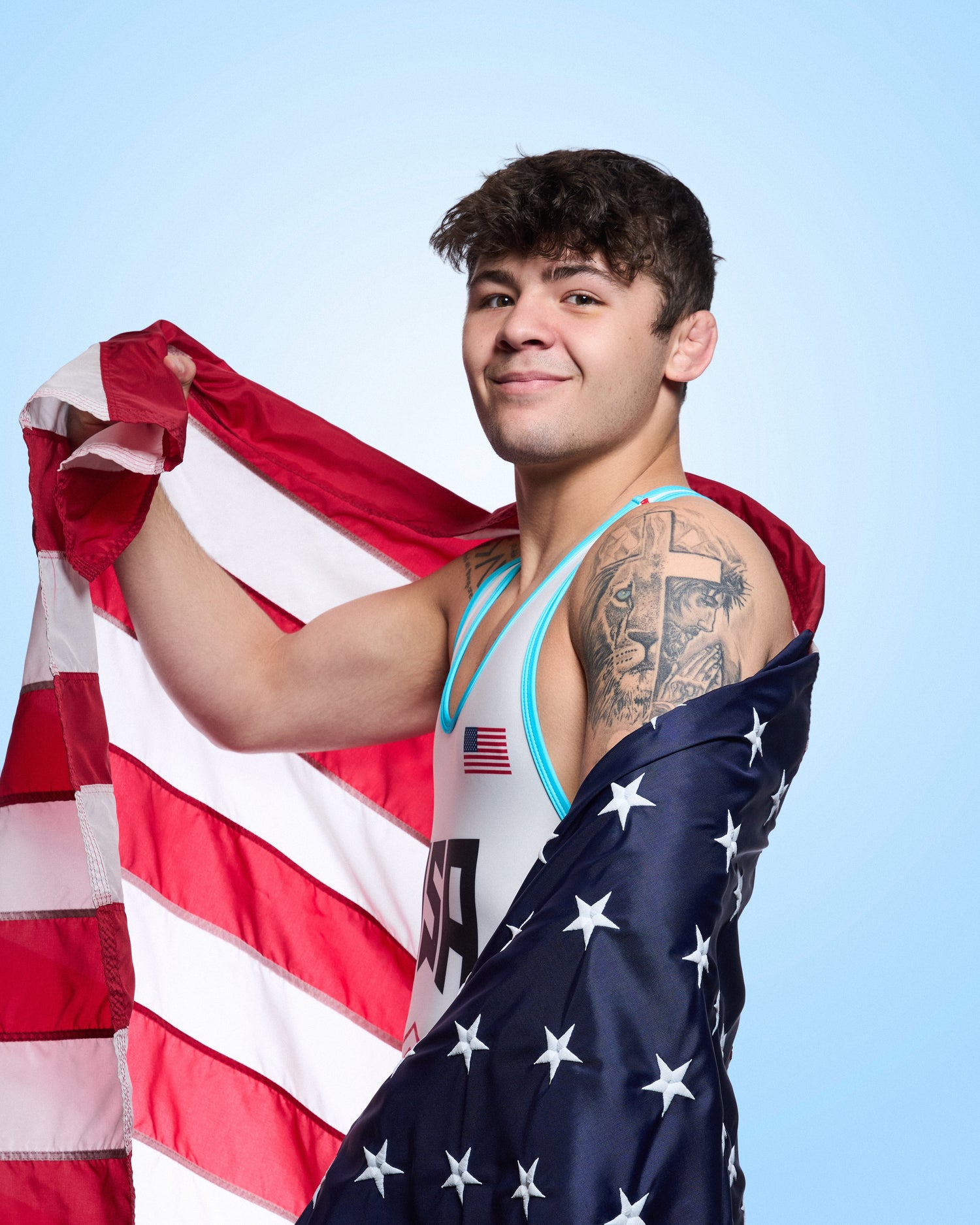 Bo Bassett holding an American flag against a light blue background