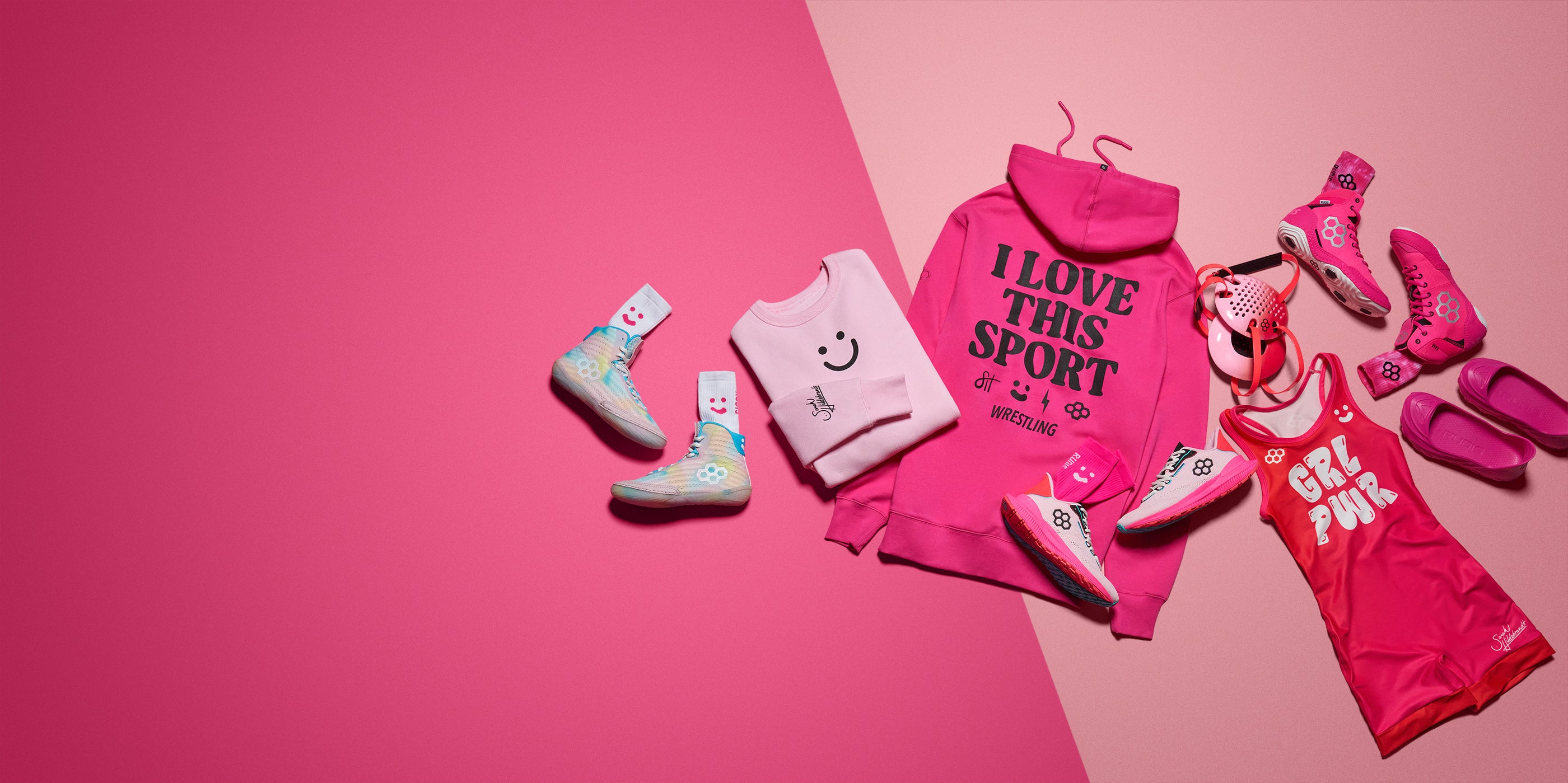 Collection of Pink RUDIS Apparel, pink RUDIS wrestling shoes and pink RUDIS wrestling gear on a two toned pink background.