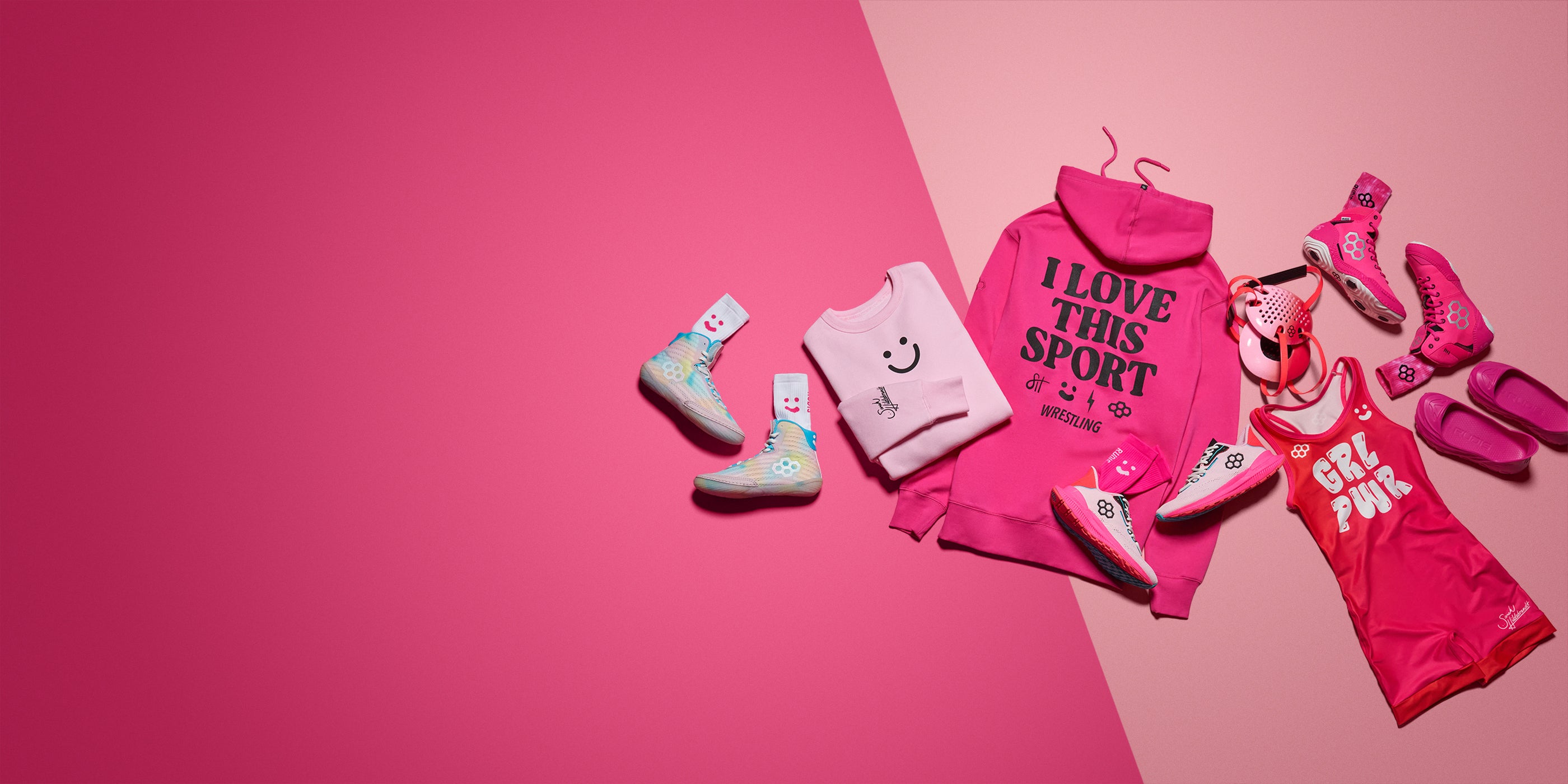 Collection of Pink RUDIS Apparel, pink RUDIS wrestling shoes and pink RUDIS wrestling gear on a two toned pink background.
