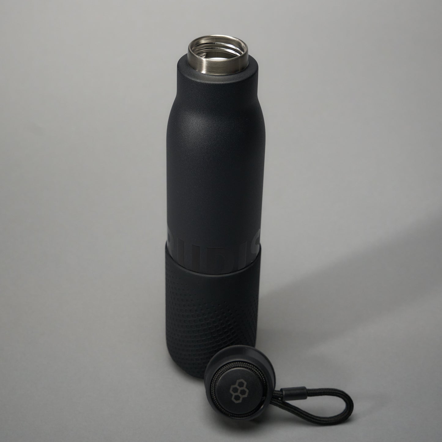 A sleek black insulated water bottle featuring a textured grip and a stainless steel opening accompanied by a detachable lid with a loop for easy carrying