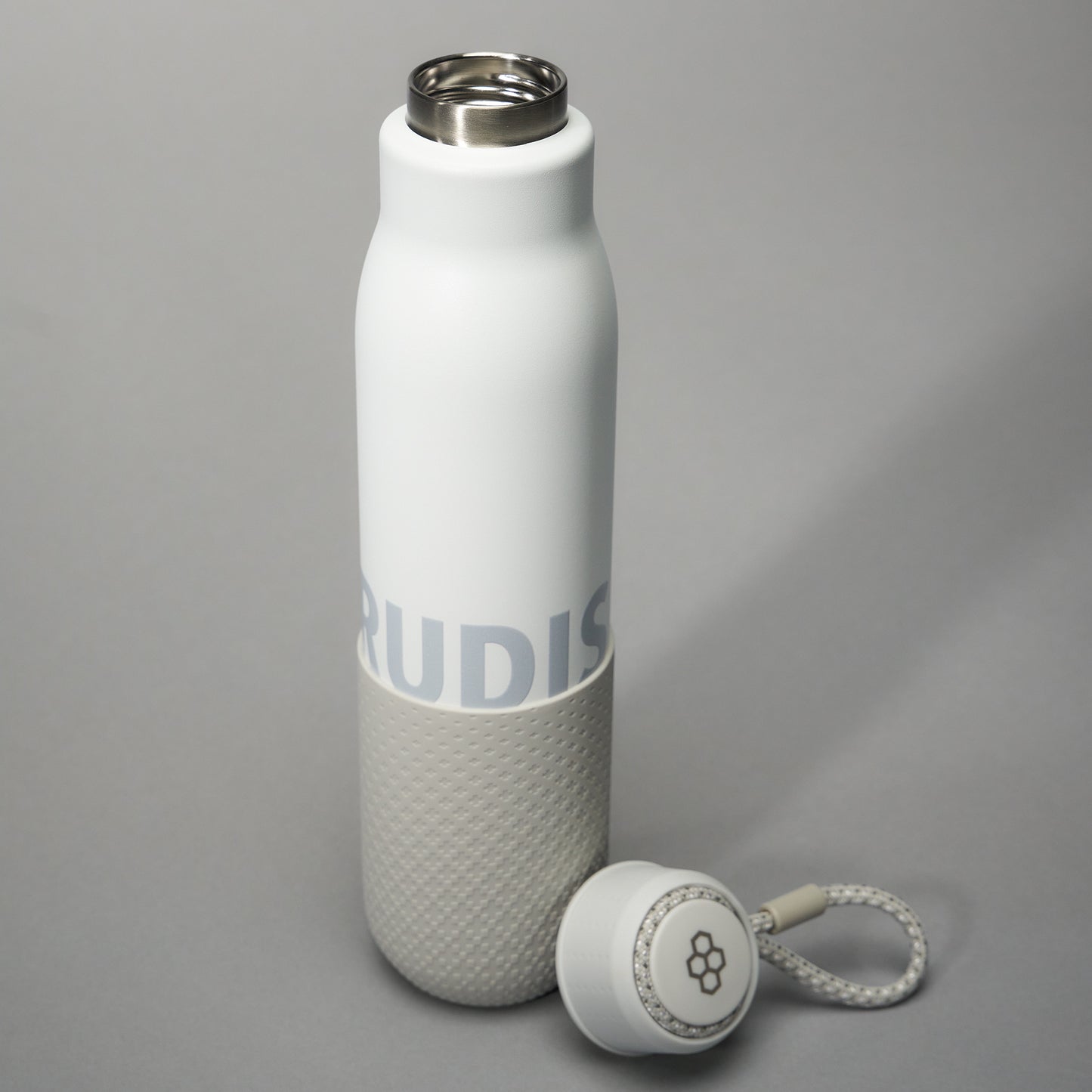 A sleek insulated white water bottle with a gray textured base and a detachable cap featuring a lace attachment