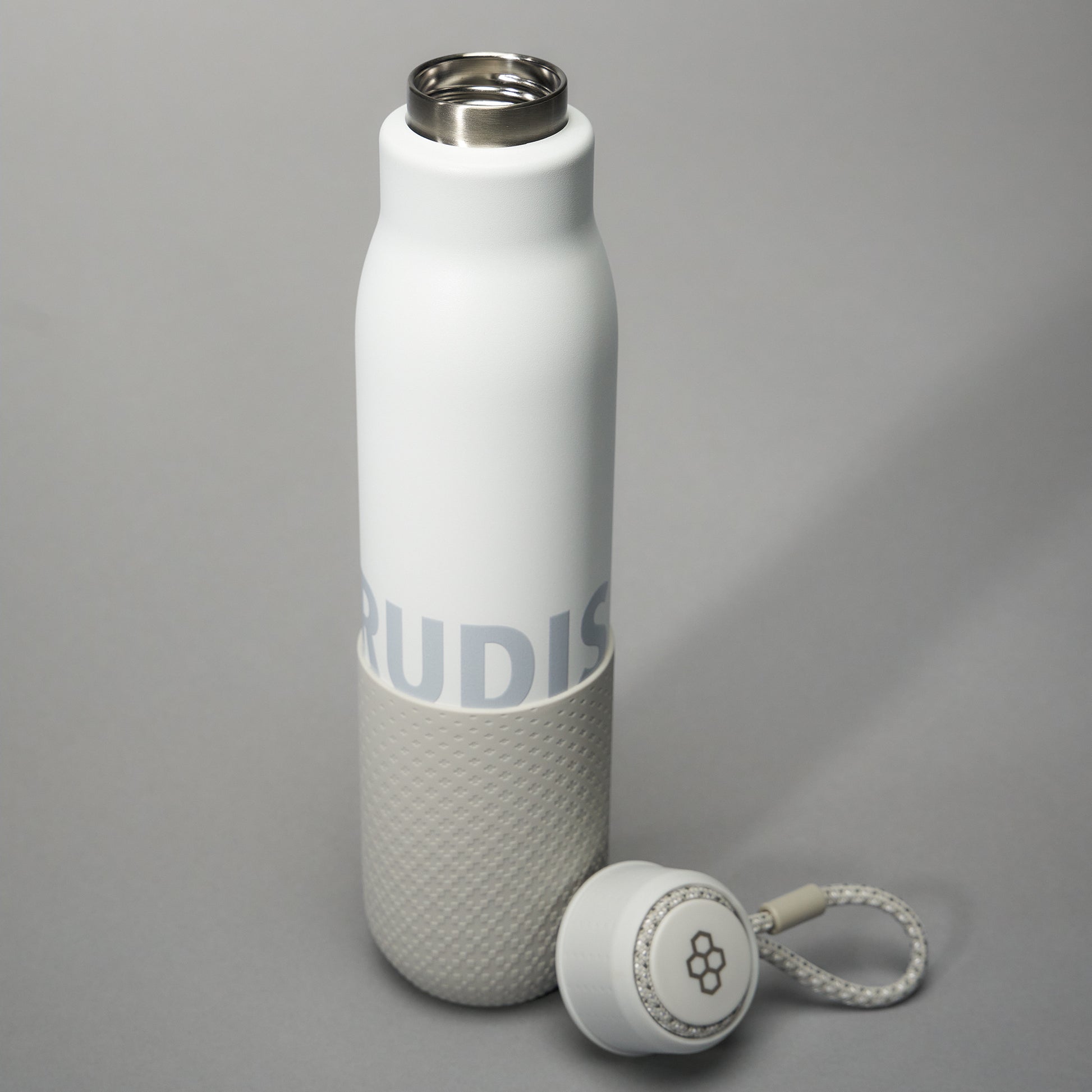 A sleek insulated white water bottle with a gray textured base and a detachable cap featuring a lace attachment