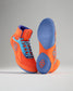 Vibrant orange wrestling shoes with blue accents and a textured sole for optimal grip and performance