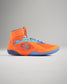 A vibrant pair of orange wrestling shoes featuring a breathable mesh design and blue accents optimized for performance and grip