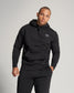 A male model wearing a black hoodie and matching sweatpants showcasing a contemporary casual style against a neutral background