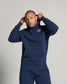 A young man in a navy blue hoodie adjusted his hood showcasing a stylish and casual look