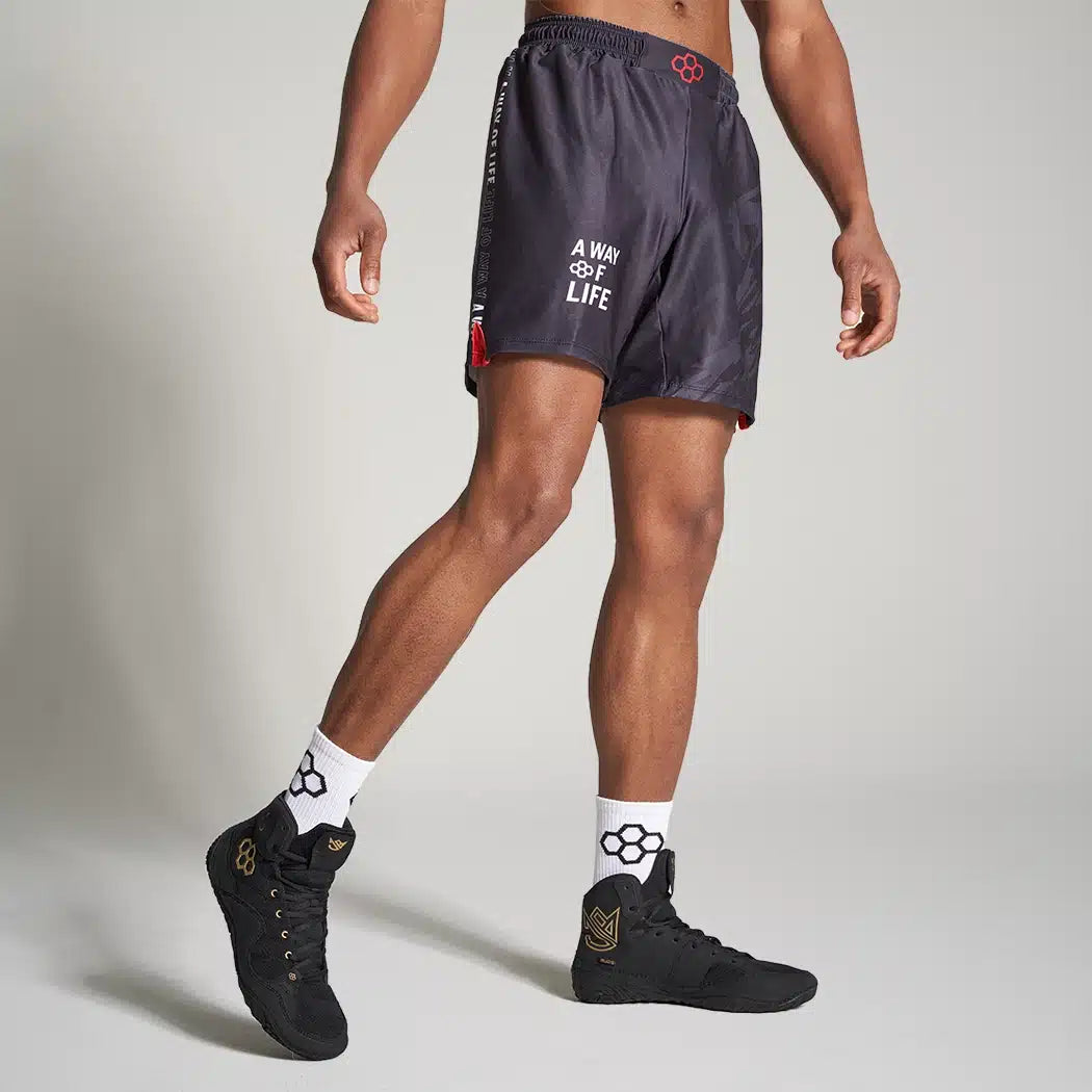 A male model wearing stylish black athletic shorts and matching high-top sneakers showcasing a sporty and contemporary look