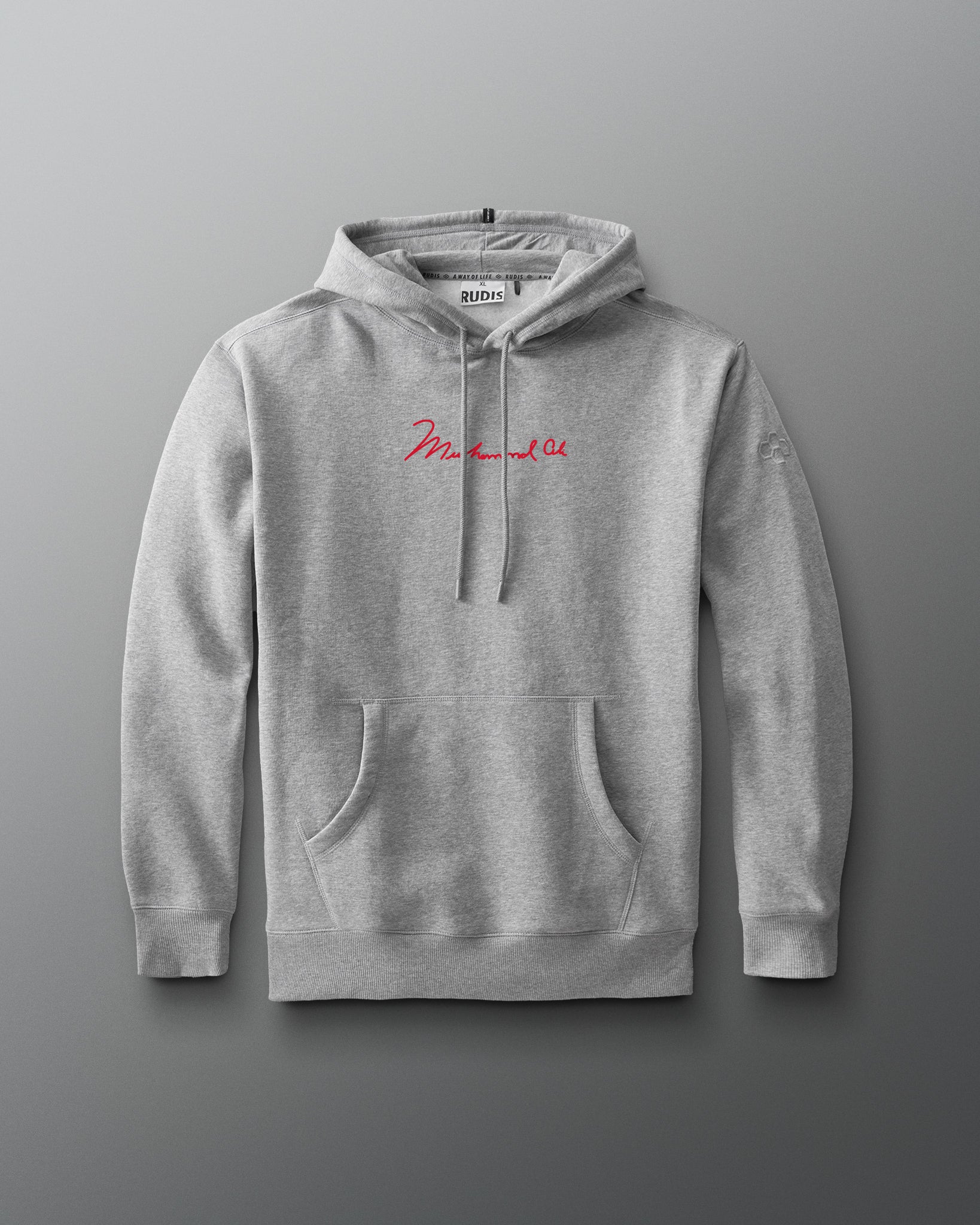 RUDIS Ali The Greatest Comfort Fleece Hoodie in gray, featuring Muhammad Ali’s signature in red across the chest, a kangaroo pocket, drawstring hood, and subtle RUDIS Hex sleeve branding.