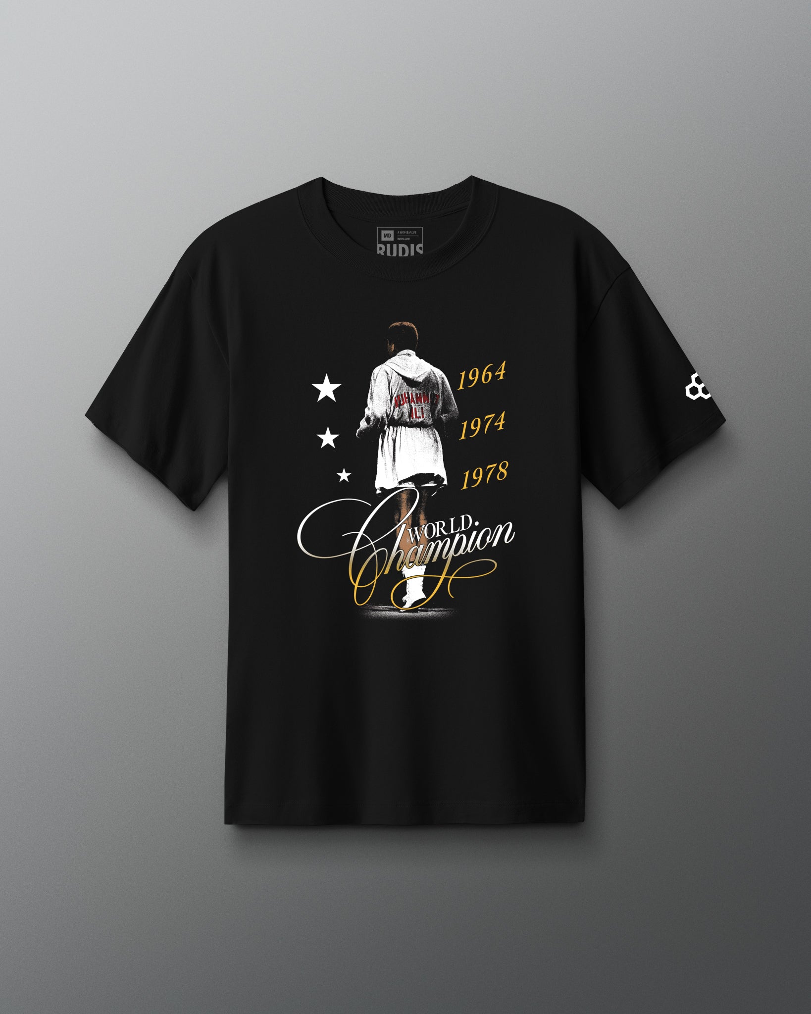 RUDIS Ali World Champion Heavyweight T-Shirt in black, featuring a Muhammad Ali-inspired championship graphic with 1964, 1974, and 1978 title years, World Champion script, and RUDIS Hex sleeve branding.