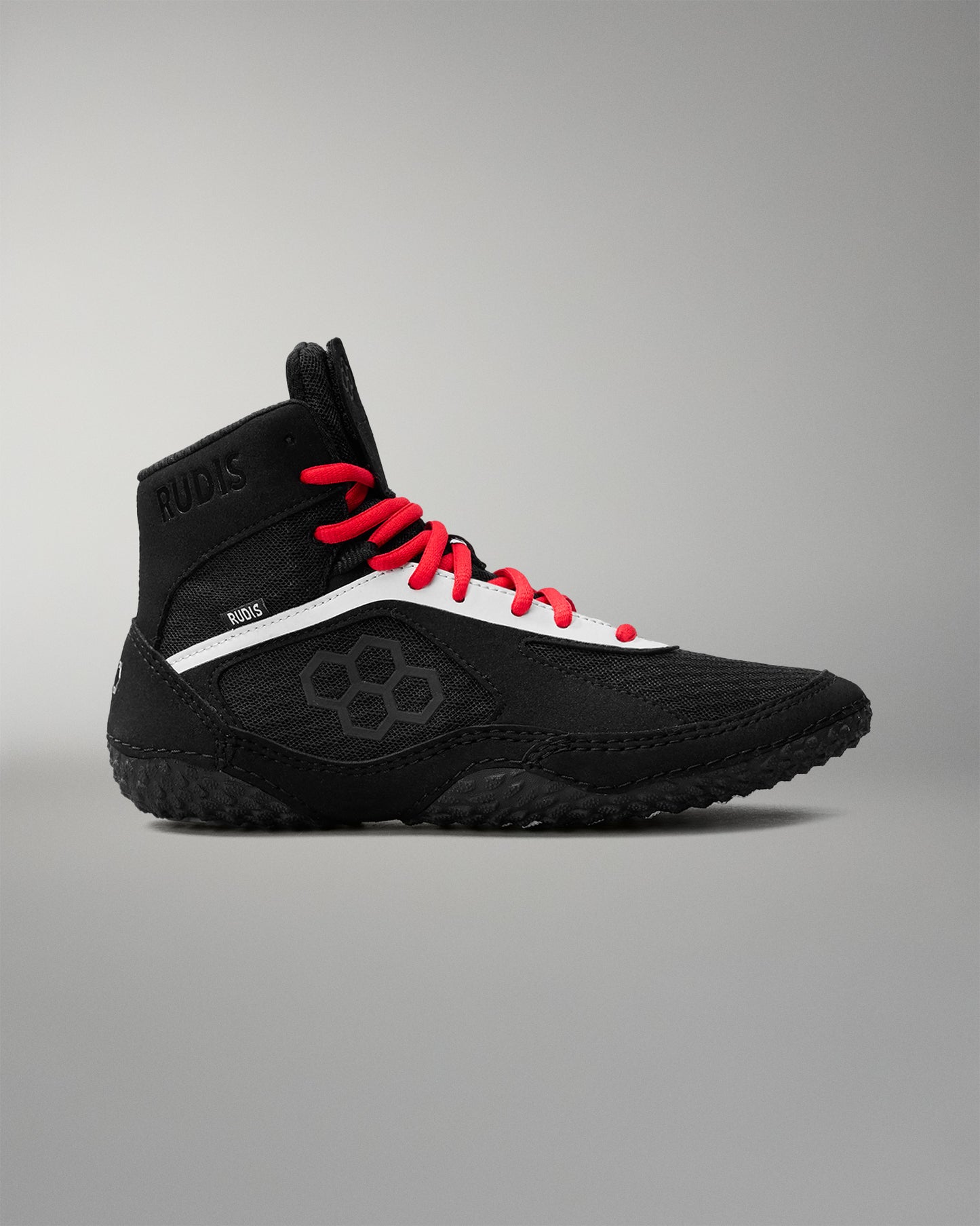 Black wrestling shoe with red laces on a gray background