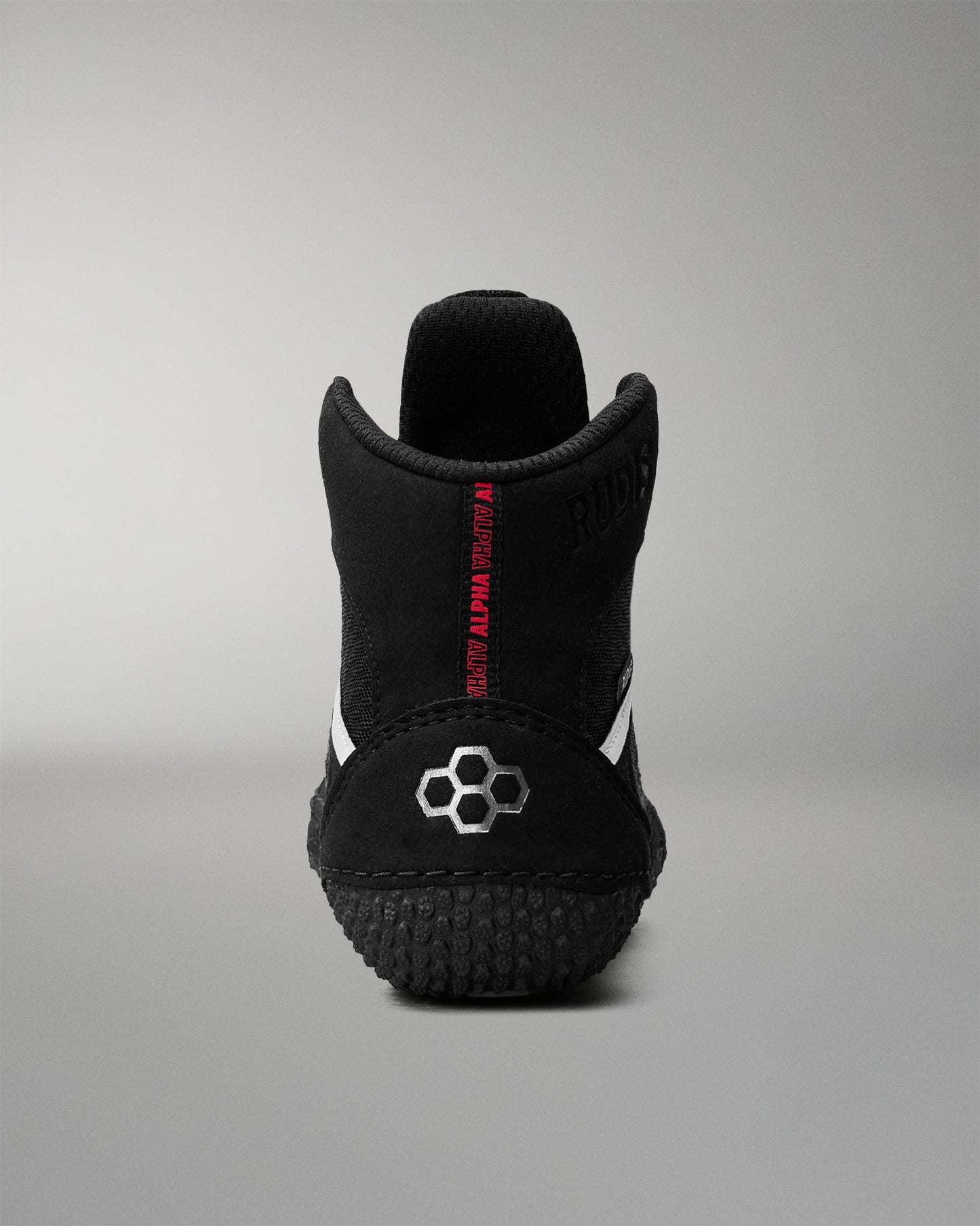 Black wrestling shoe with red text on a gray background