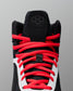 Black wrestling shoe with red laces on a gray background