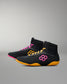 Black wrestling shoes with pink and yellow accents on a gray background