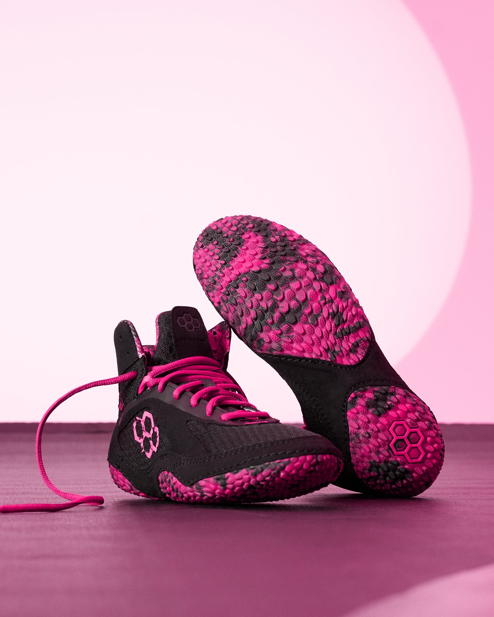 RUDIS Alpha 2.0 wrestling shoes in Pink Power colorway with black and pink design, highlighting lightweight construction, aggressive grip traction, and mat-ready performance