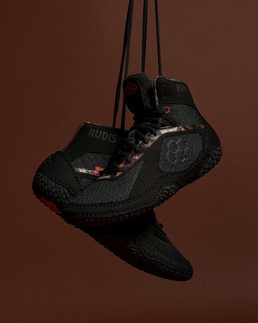RUDIS Alpha 2.0 wrestling shoes in Terrain colorway with blacked-out design and rugged detailing, emphasizing durability, grip traction, and controlled mat performance