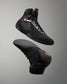 Black wrestling shoe with orange accents on a gray background