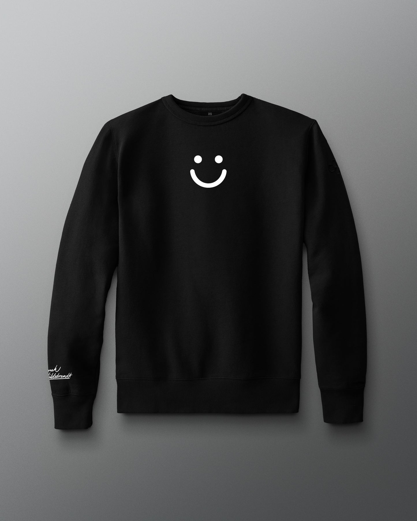 Black sweatshirt with a smiley face design on a gray background