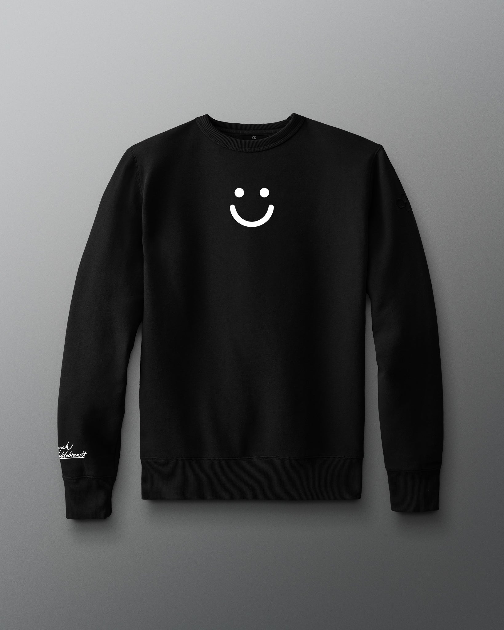 Black sweatshirt with a smiley face design on a gray background