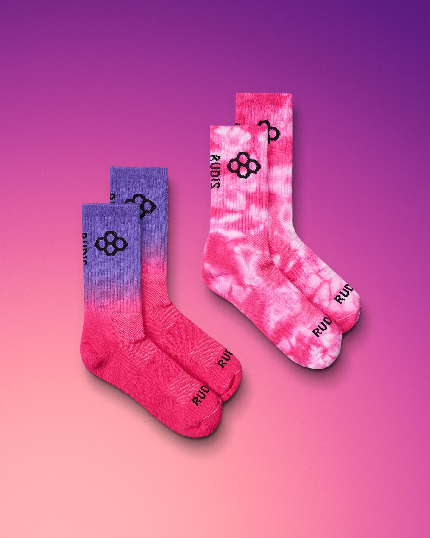 Two pairs of socks with a gradient design on a pink and purple gradient background.