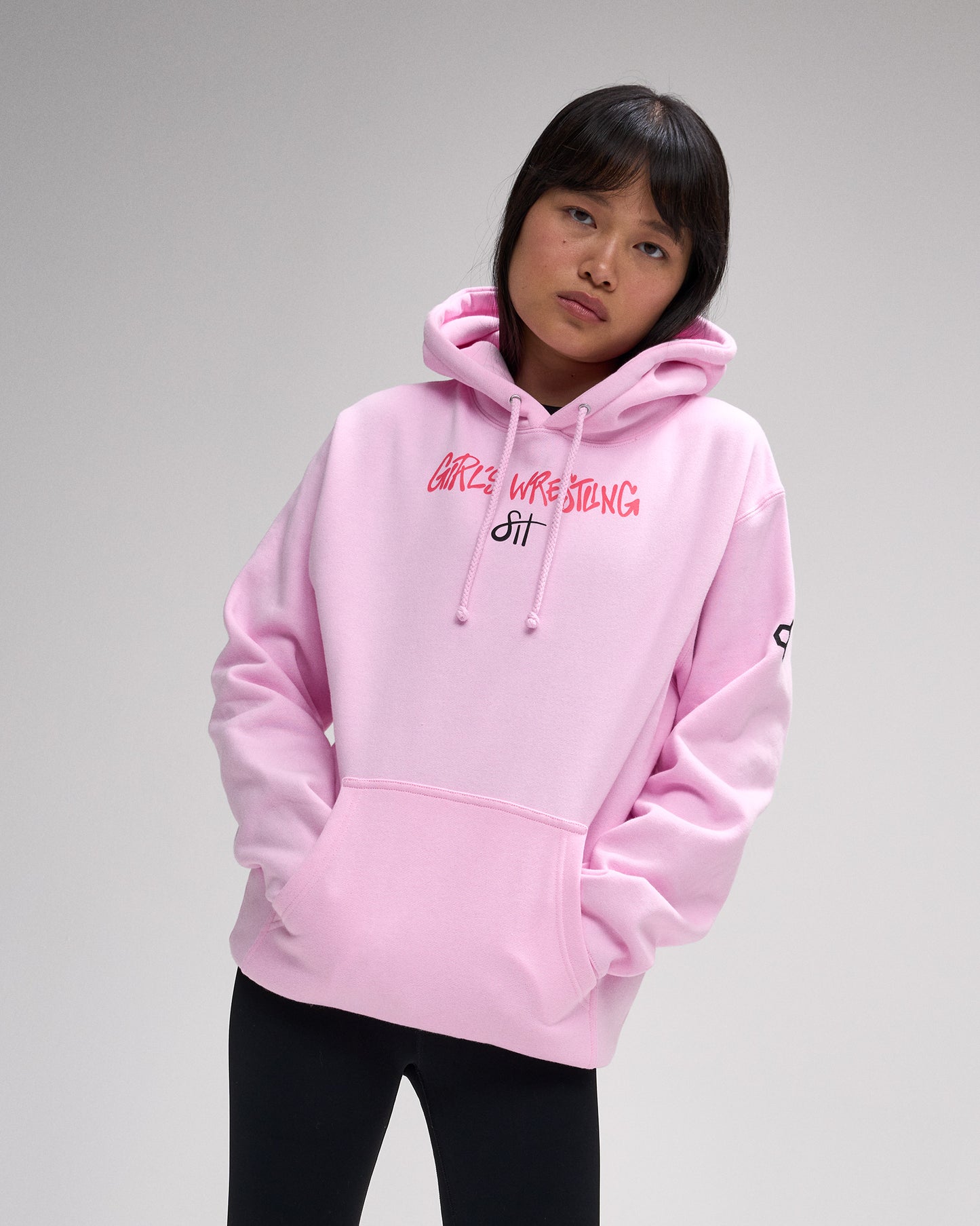 Person wearing a pink hoodie with text on a gray background