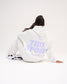 Seated female model showing the back of the RUDIS Love This Sport Heather Silver fleece hoodie with a large lavender I Love This Sport wrestling graphic.