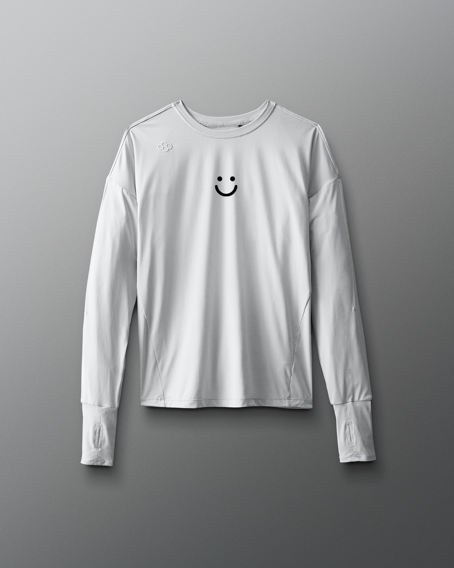 White long-sleeve shirt with a smiley face design on a gray background