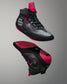 Black and pink wrestling shoes on a gray background