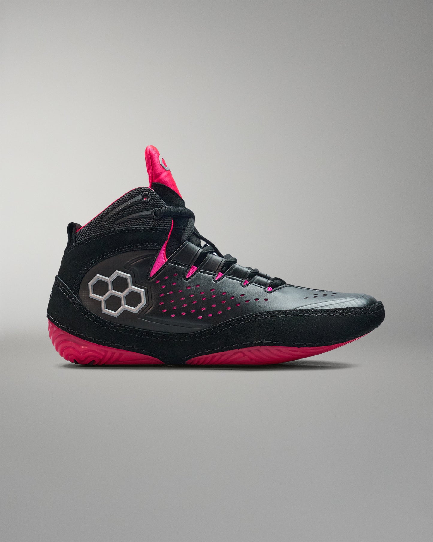 Black and pink wrestling shoe on a gray background