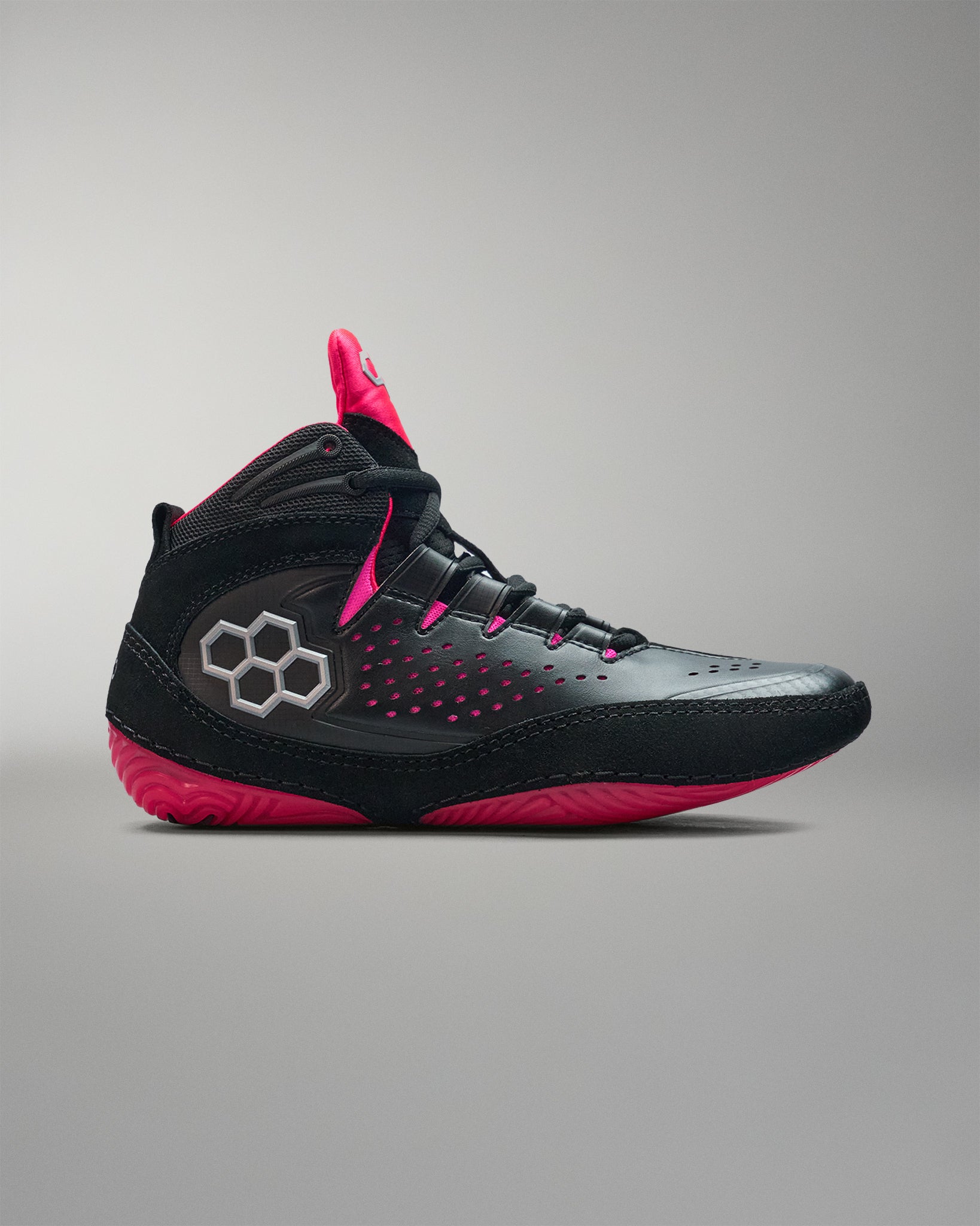Black and pink wrestling shoe on a gray background