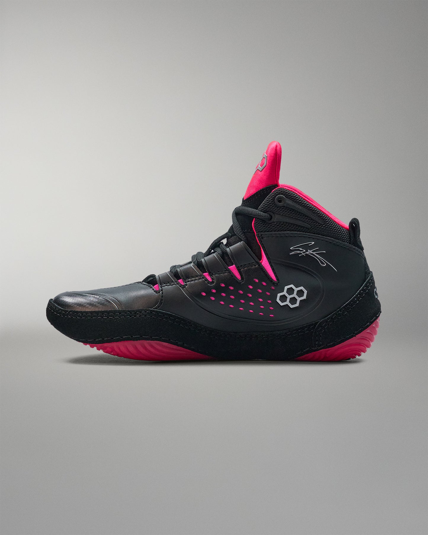 Black and pink wrestling shoe on a gray background