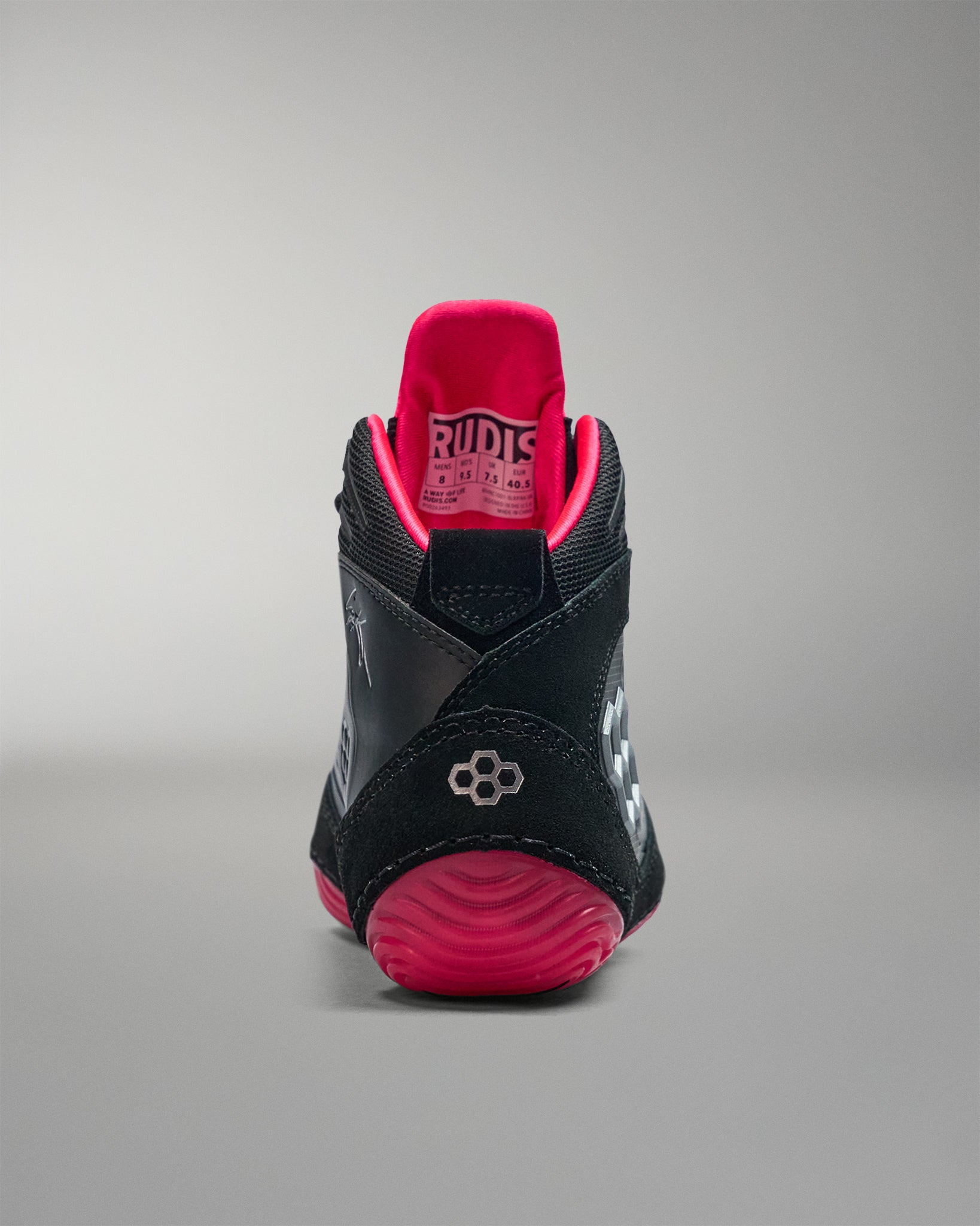 Black and pink wrestling shoe on a gray background