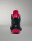 Black and pink wrestling shoe on a gray background