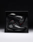 Black wrestling shoes with red accents in a black box on a dark background - Cary Kolat wrestling shoes
