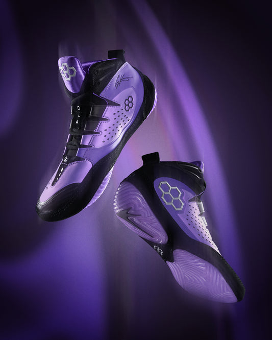 Purple and black wrestling shoes with a glowing effect on a dark background