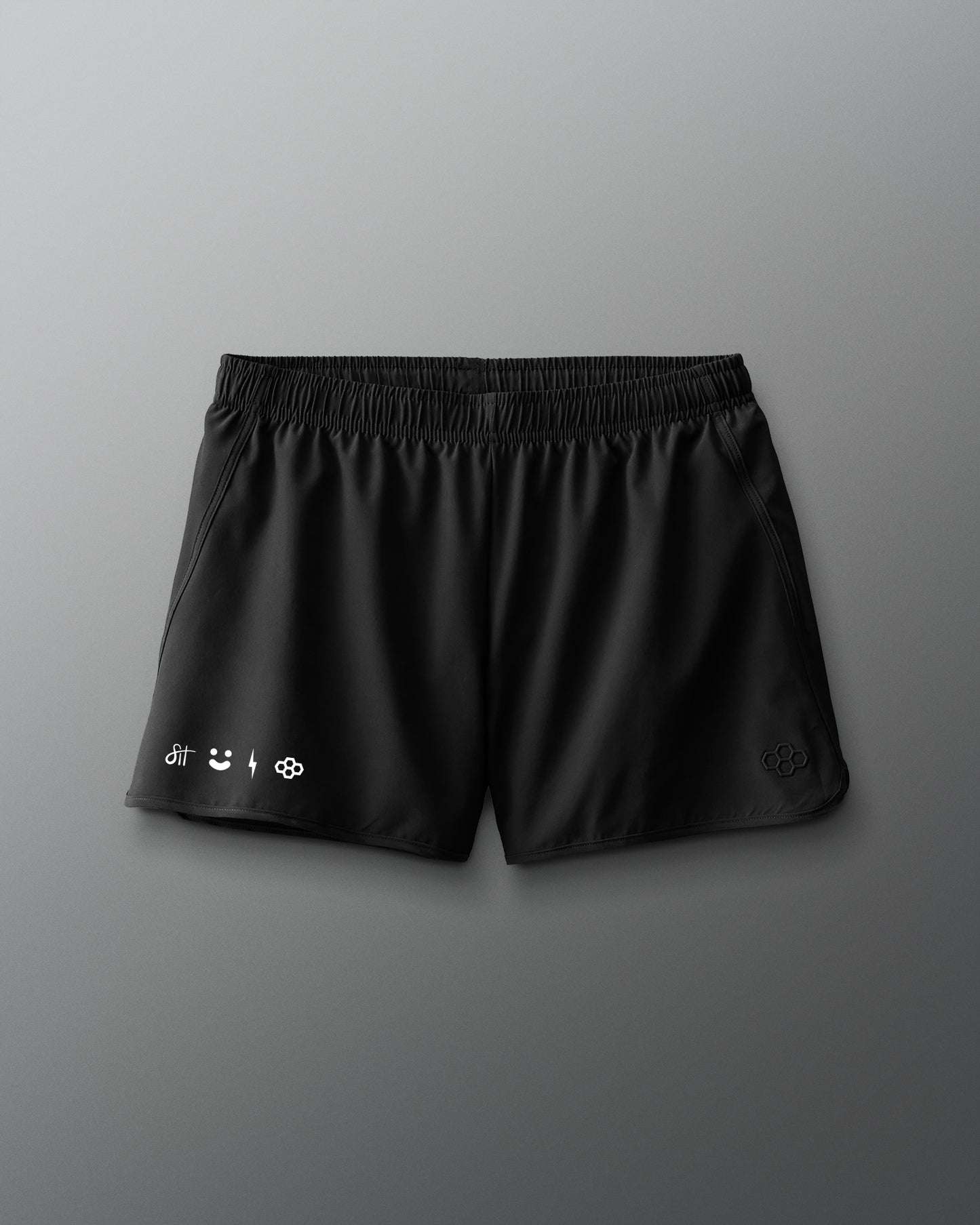 Black shorts with brand logos on a gray background