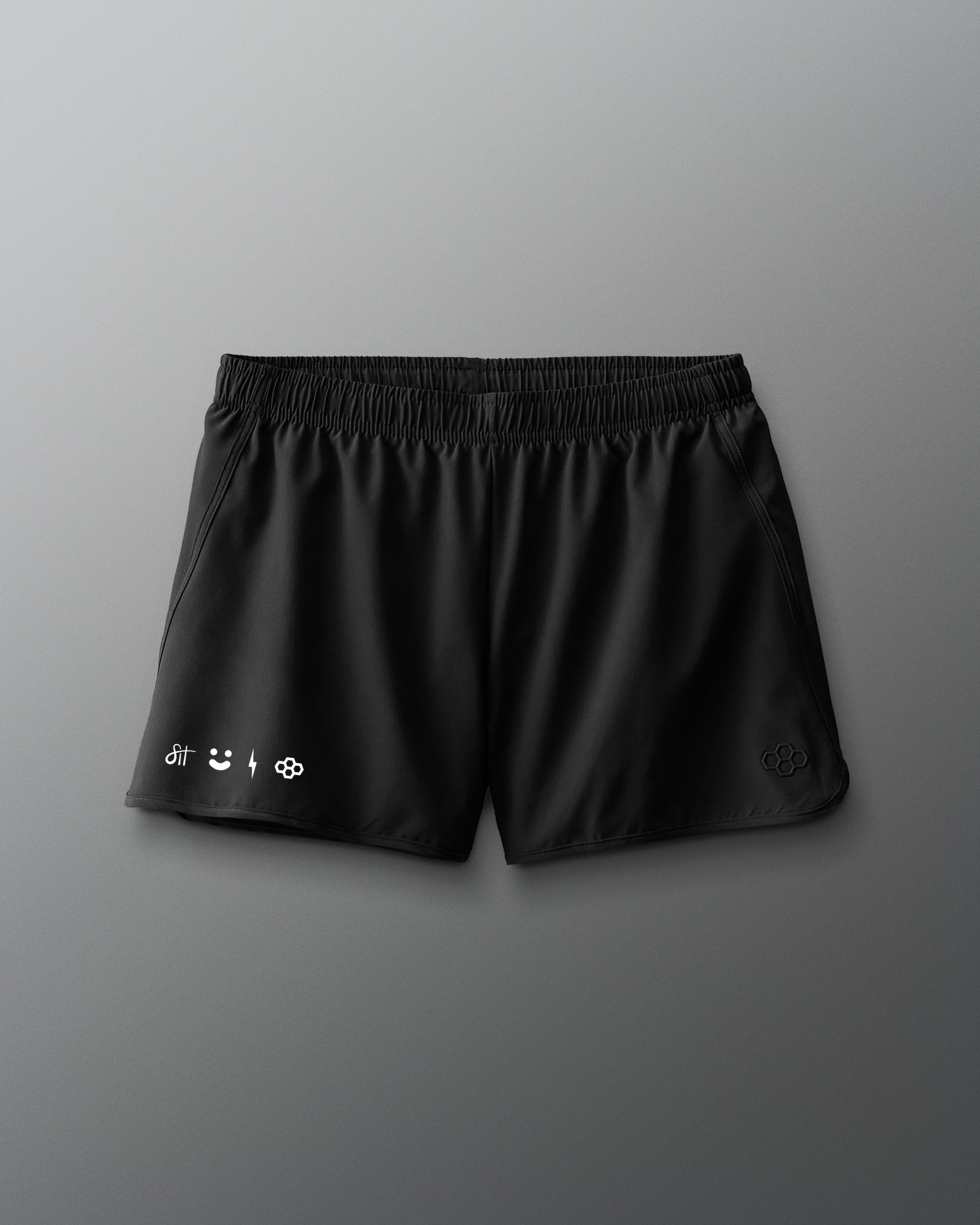 Black shorts with brand logos on a gray background