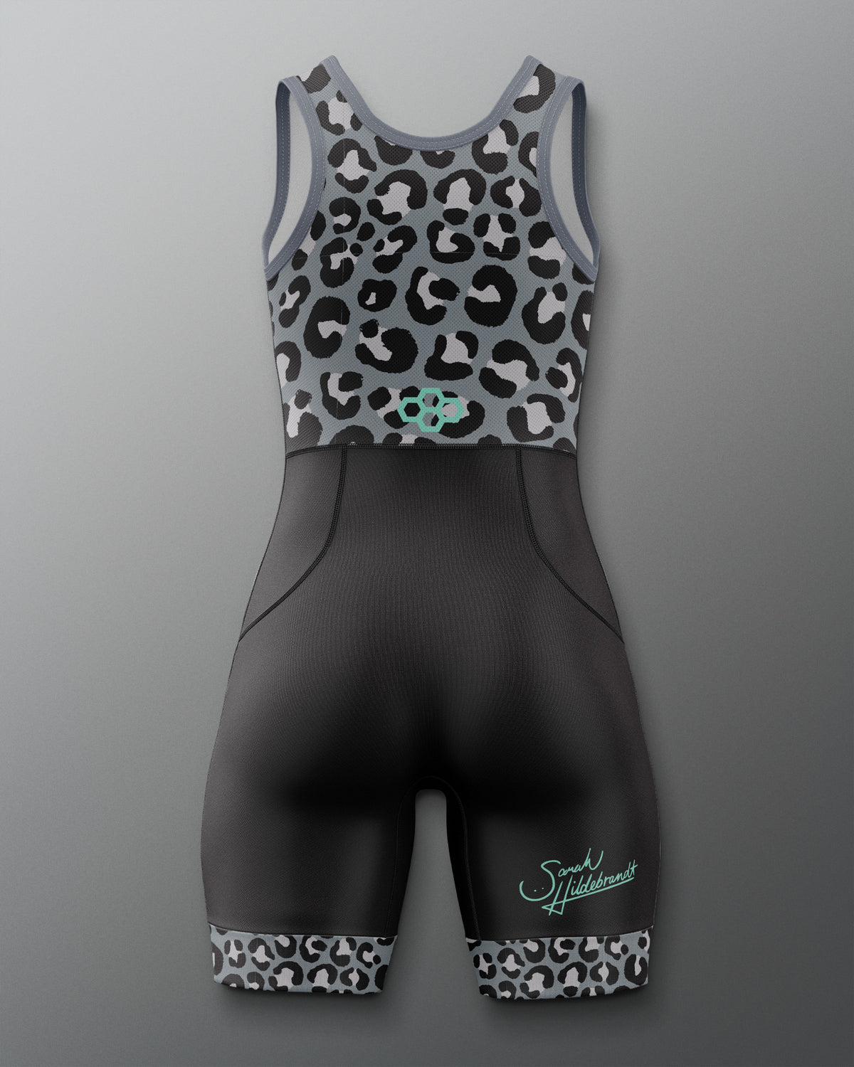 A women's athletic one-piece wrestling singlet with a gray and black leopard print bodice and matching patterned leg cuffs, paired with a solid black ribbed lower body. The brand name 'Sarah Hildebrandt' is printed in teal script on the left leg.