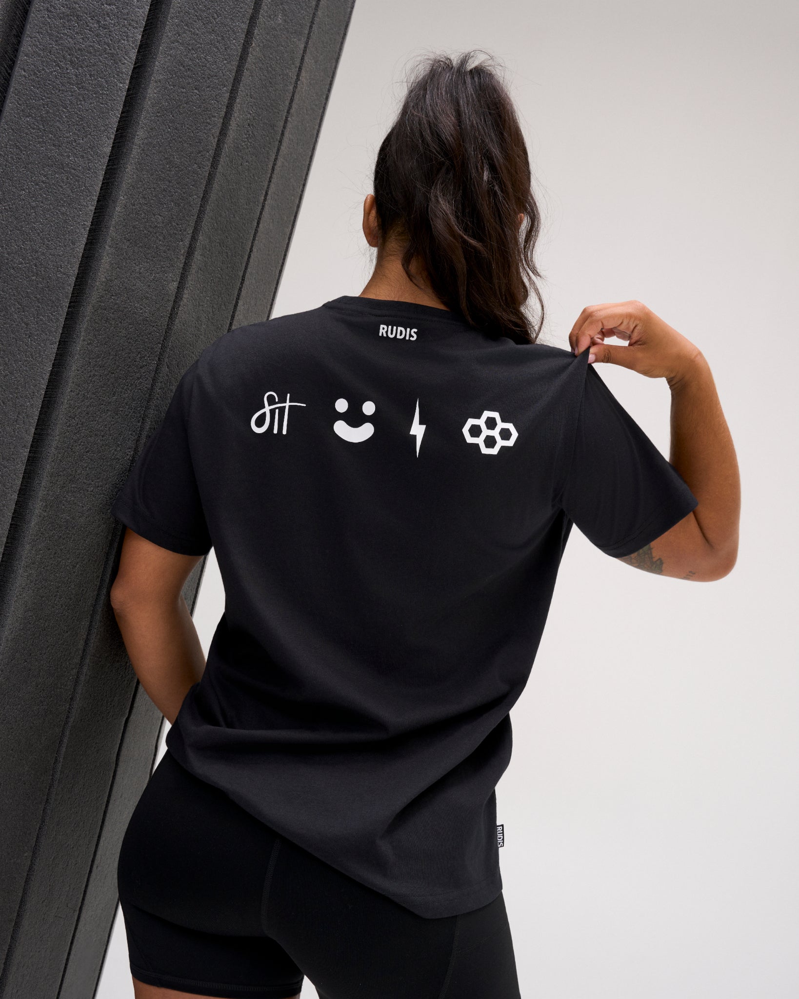 Back view of the RUDIS SH Smile Elite Super Soft T-Shirt in black, featuring white signature, smile, lightning bolt, and RUDIS graphics.