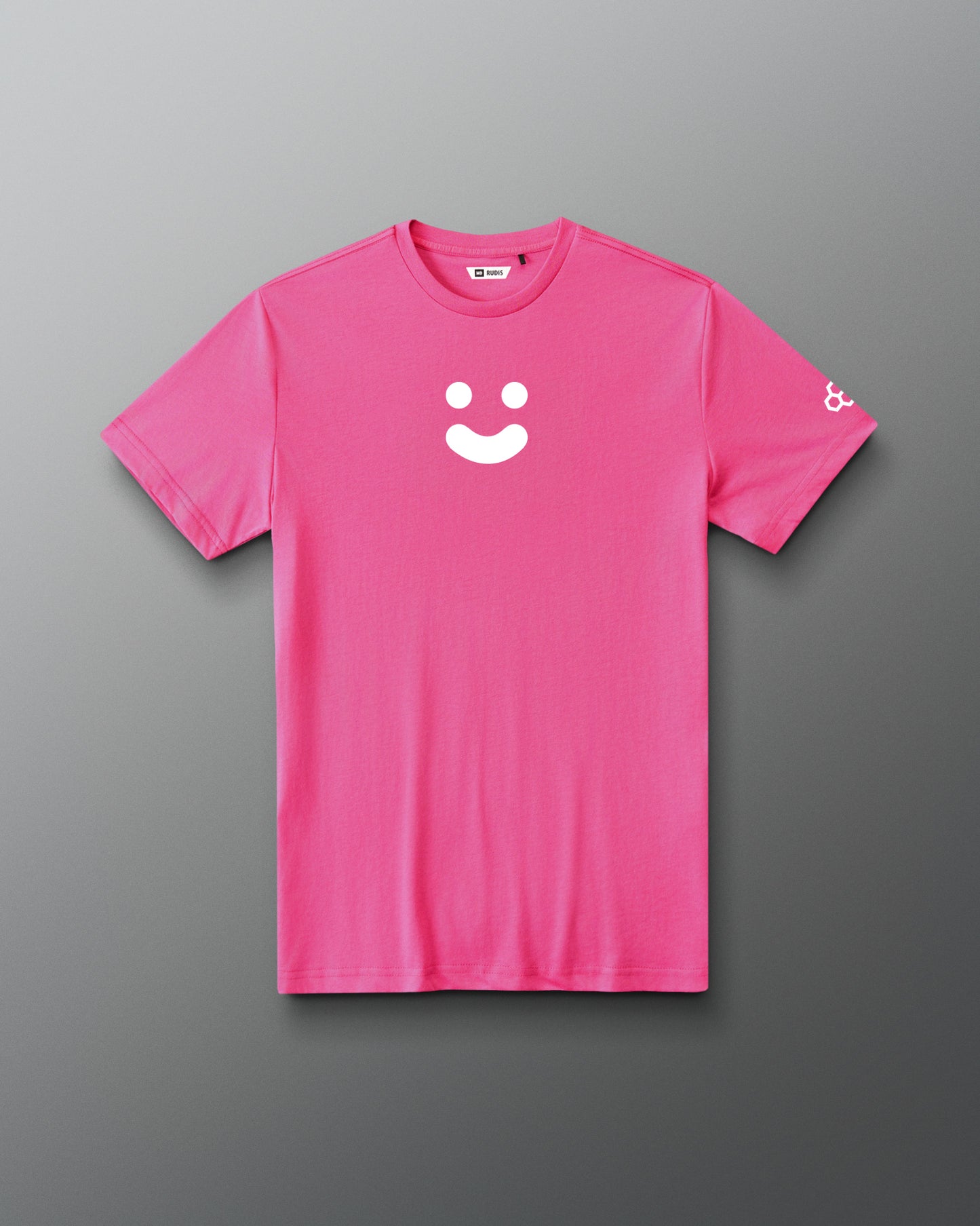 A bright pink short-sleeve crewneck t-shirt with a white minimalist smiley face graphic on the center chest and a small white logo on the left sleeve, displayed against a dark gray gradient background.