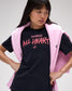 Person wearing a black t-shirt with pink text and a pink crewneck on a white background