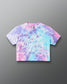 A short-sleeve crop top t-shirt featuring a pastel tie-dye pattern in pink, purple, and blue, with the phrase 'I've Been Dreaming About It' printed in white script across the front. The brand 'RUDIS' is visible on the inner neck label.
