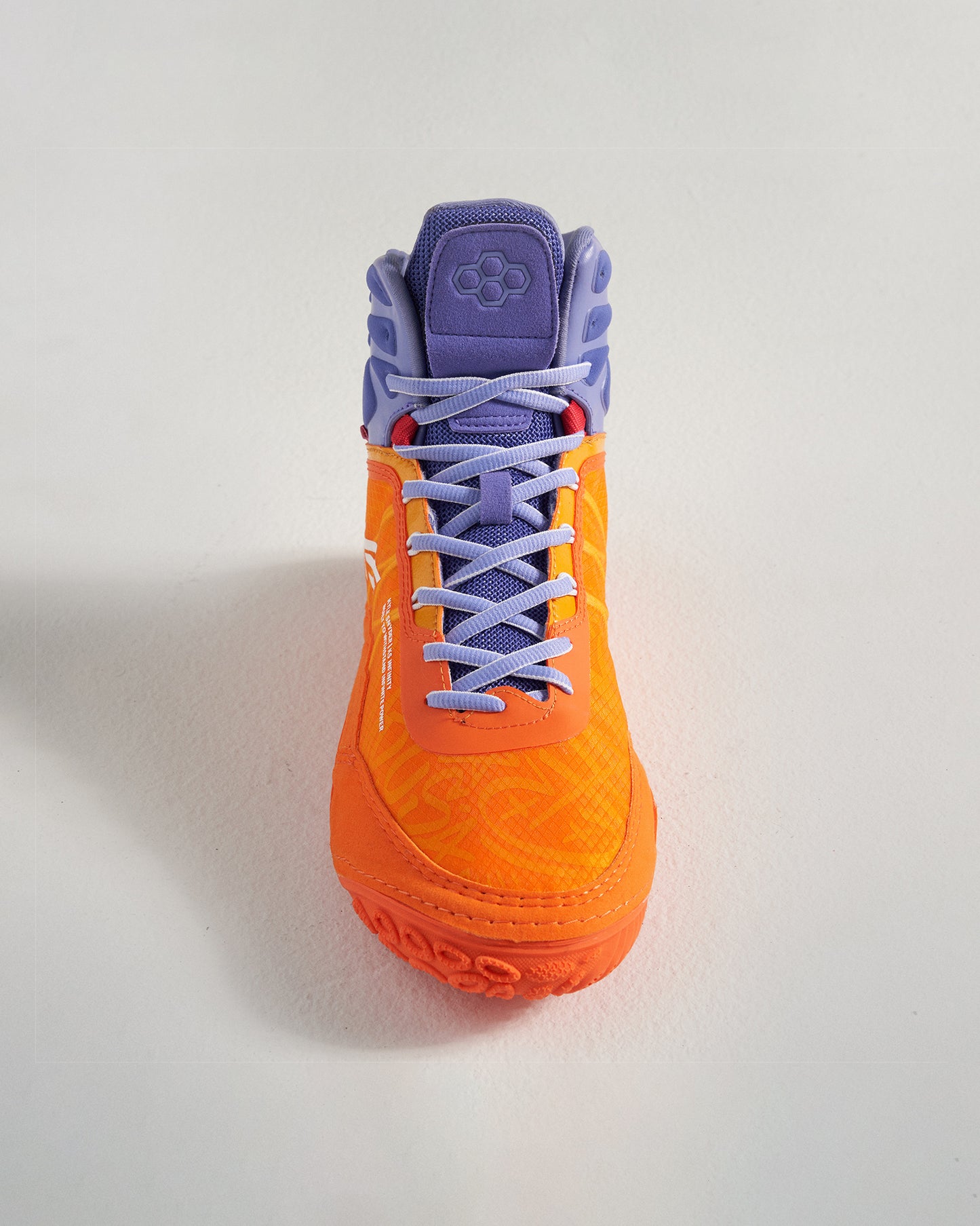 A vibrant orange athletic shoe with purple detailing and textured sole designed for performance and style